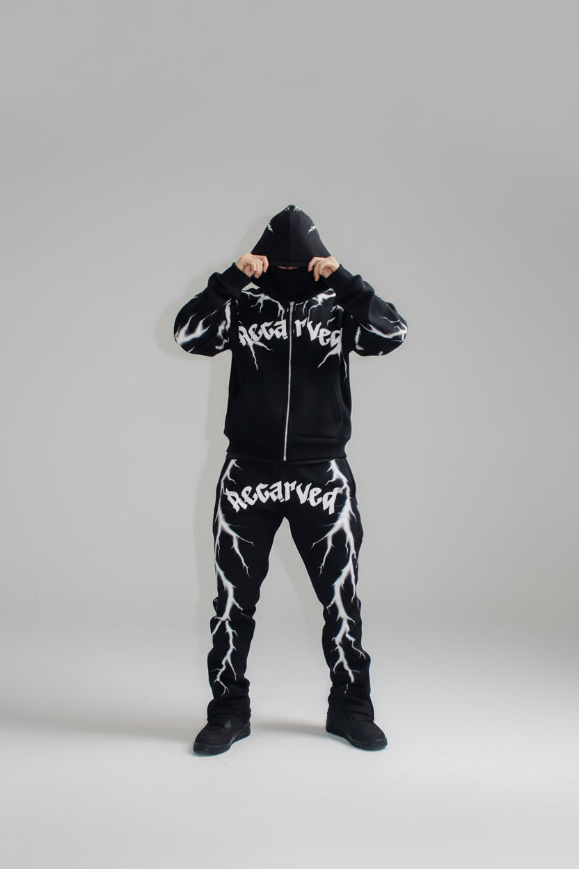 Person wearing a black hoodie and pants with 'Recarved' branding on stairs.